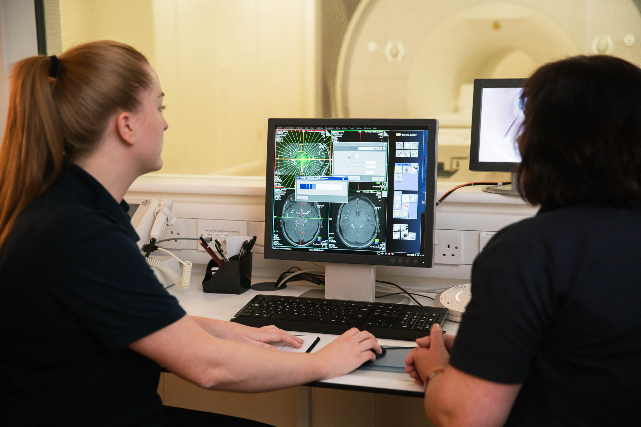 Superintendent Radiographer Charlotte Jardine and colleague examines brain scans on a computer screen