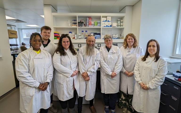 Scientists posing in the lab in white coats