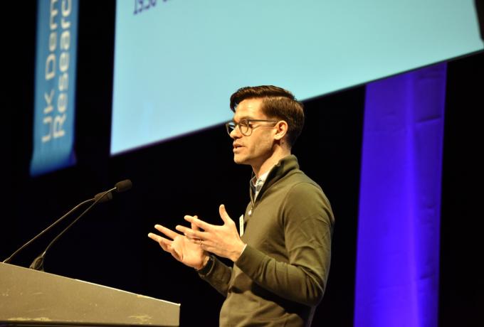 Person speaking to the audience at a lectern.