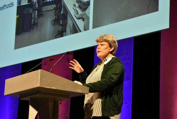 Person speaking to the audience at a lectern.