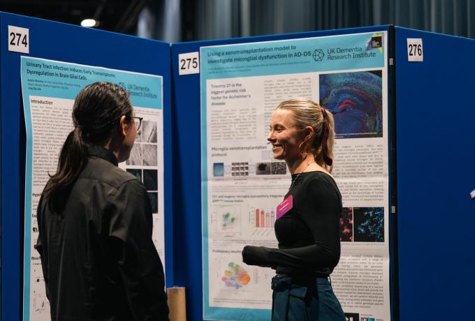 Two researchers discussing a poster