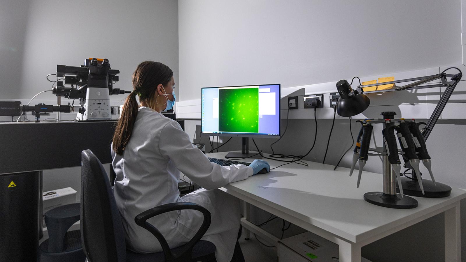 Researcher at a microscope