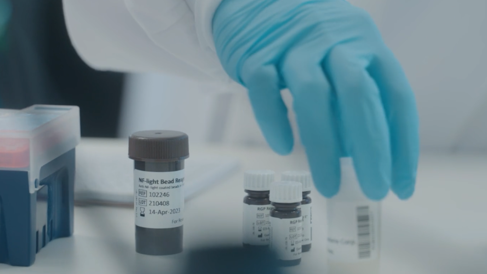 A person putting out bottles of lab equipment