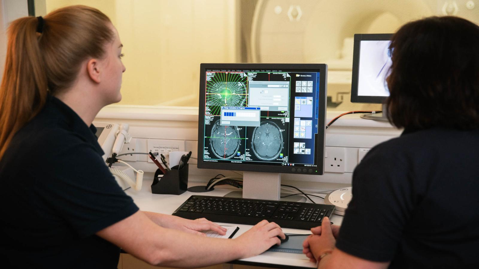 Superintendent Radiographer Charlotte Jardine and colleague examines brain scans on a computer screen