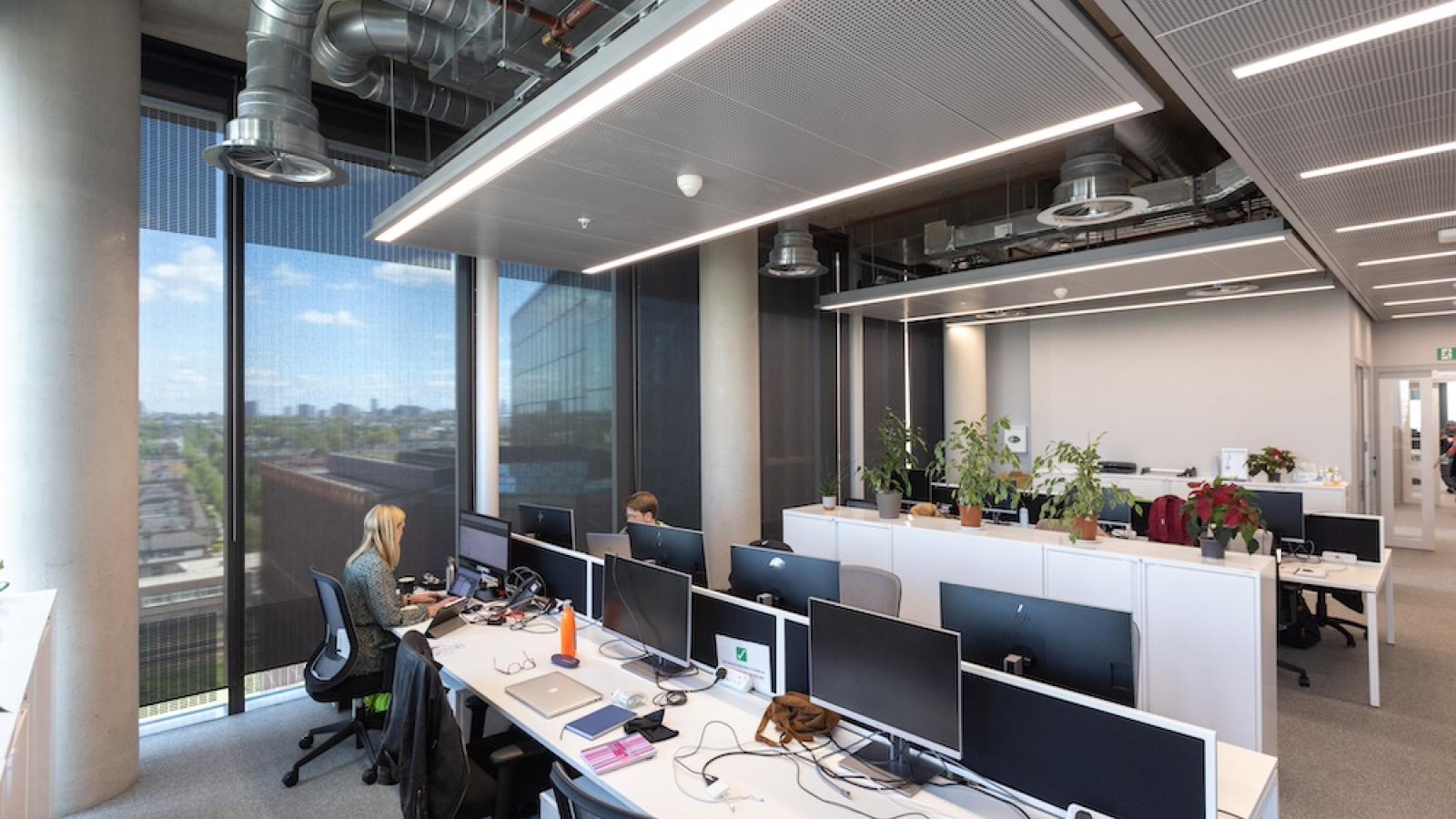 An open plan office space with people working at computer desks