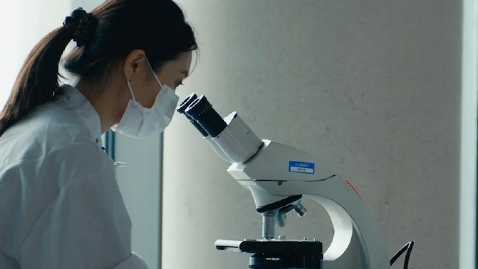 Woman looking down a microscope