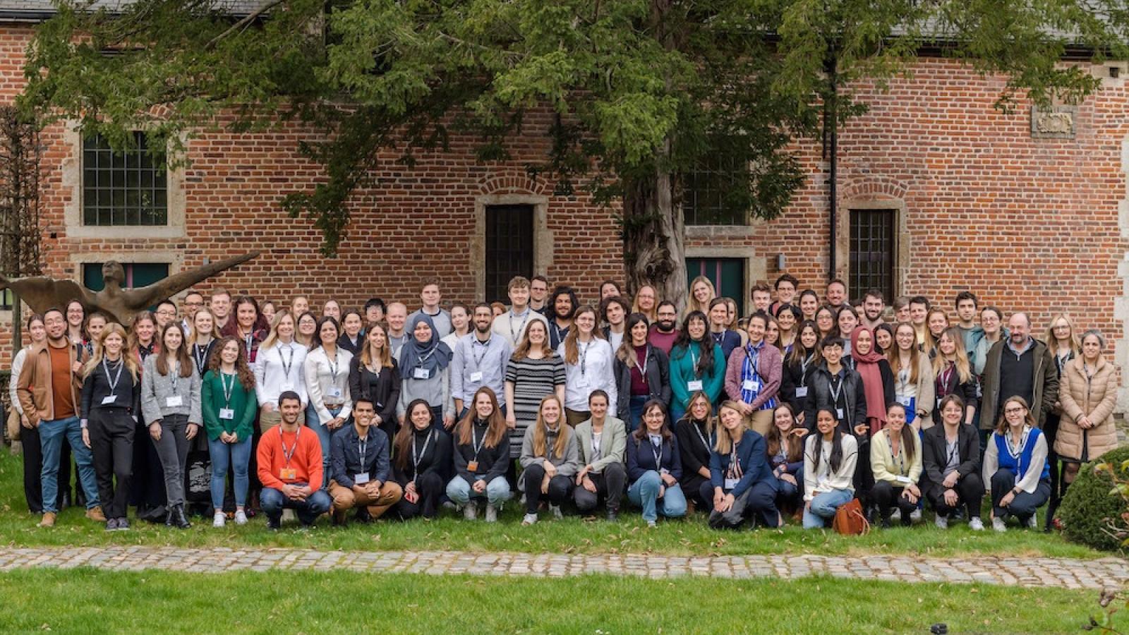 A large group posing for a picture on a grass lawn