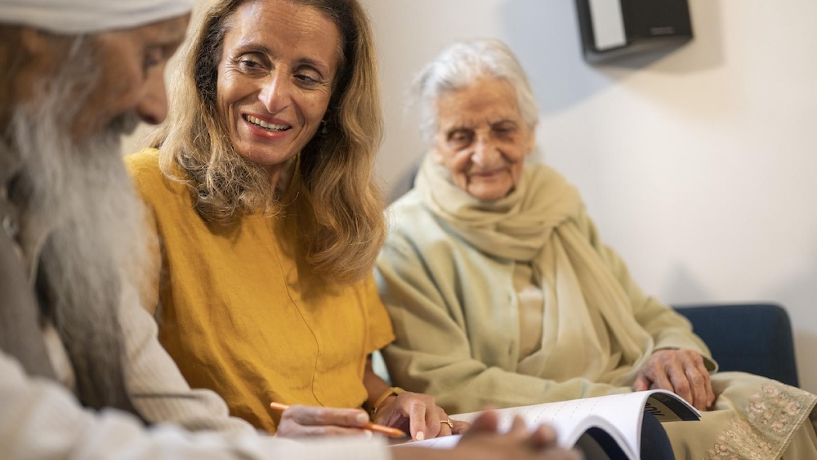 Woman with older parents sitting on sofa
