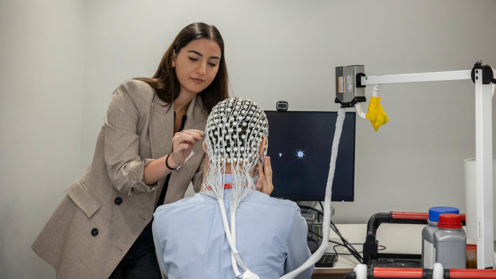 Researcher putting on EEG cap