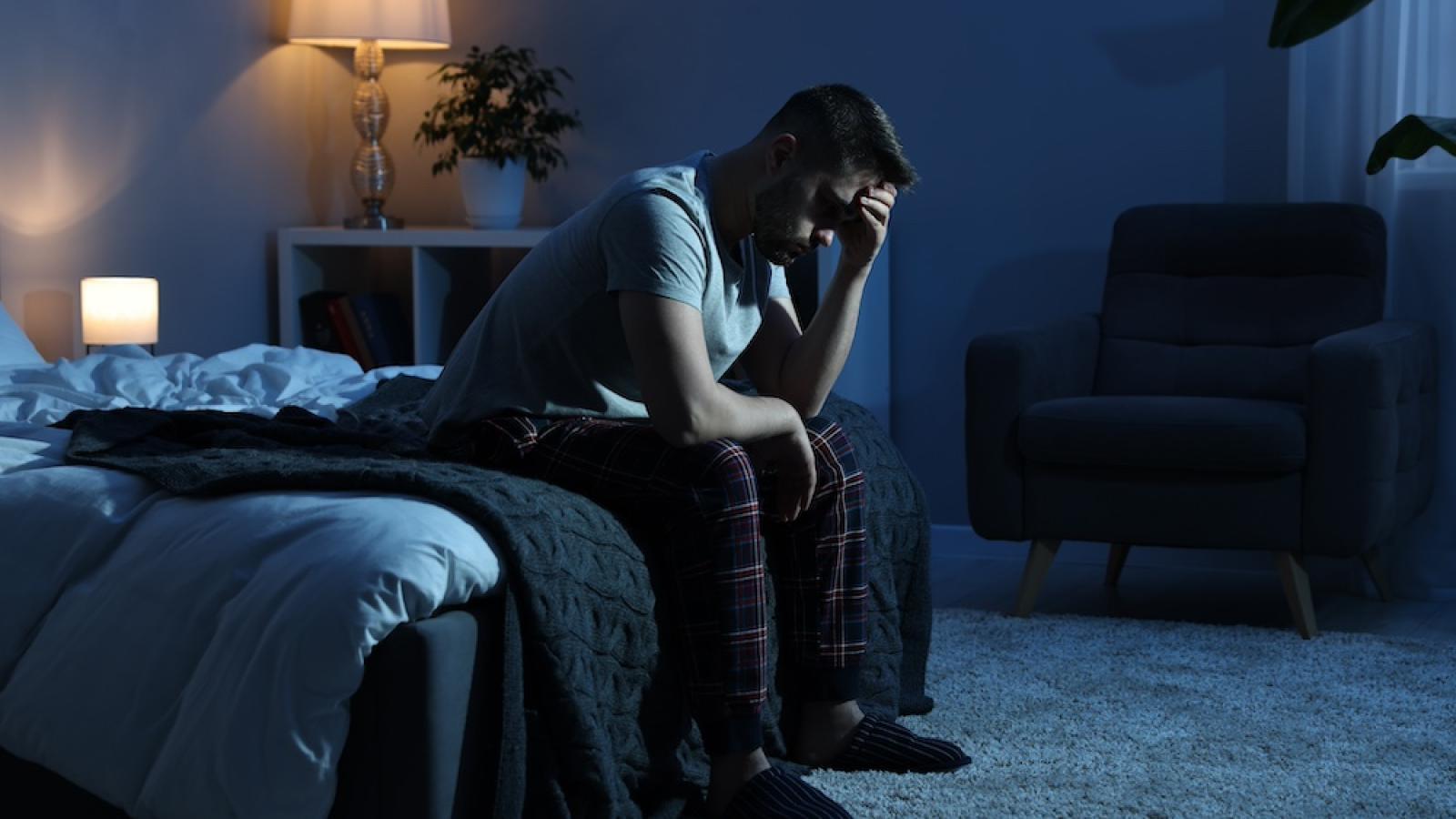 man sitting on bed at night