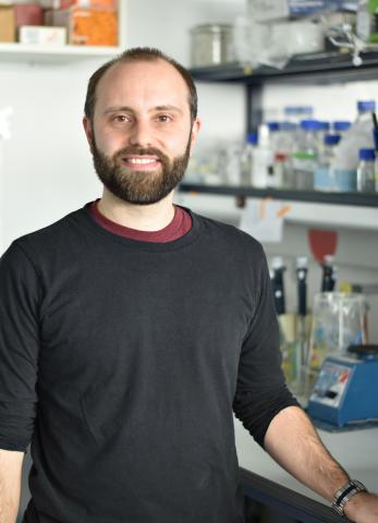 Smiling man with dark hair and dark short beard