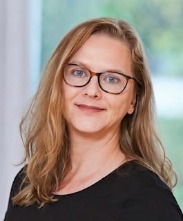 Female with long wavy blonde hair and glasses