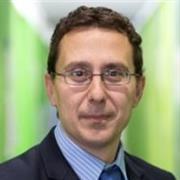 Male with dark brown hair and glasses, against a green background