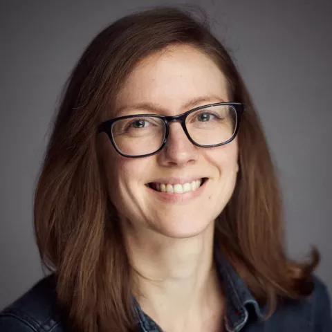 Smiling female with glasses and dark brown hair