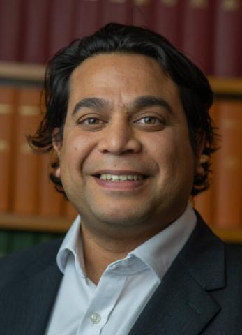 Smiling male with medium length wavy black hair