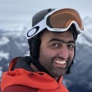 Male with red jacket, ski helmet and ski goggles