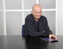 White male with glasses sat at a table