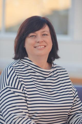 Female with dark brown shoulder length hair and a side fringe