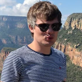 Male with grey hair and sunglasses, wearing a striped top