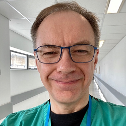 Smiling male with grey hair and glasses