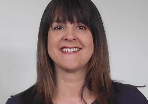 Female with long dark brown hair and a straight fringe