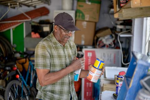 A man in a garage with cans