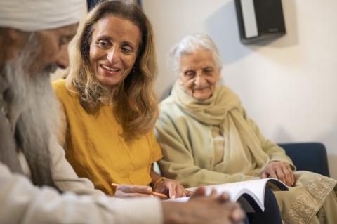 Woman with older parents sitting on sofa