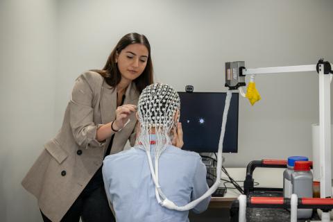 Researcher putting on EEG cap