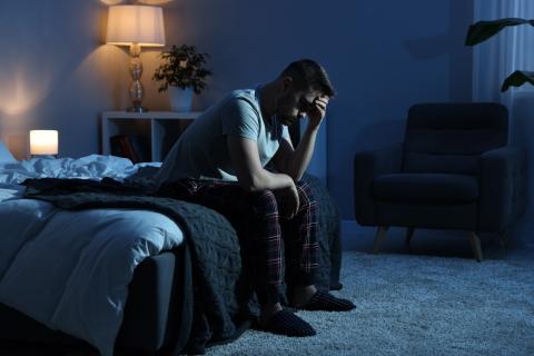 man sitting on bed at night