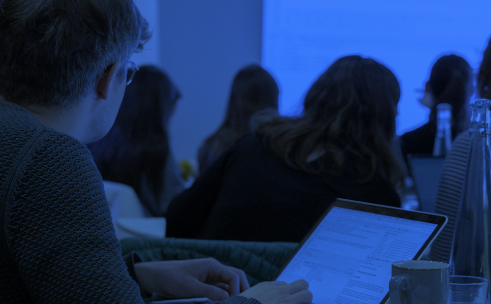 People sit at laptops in a seminar