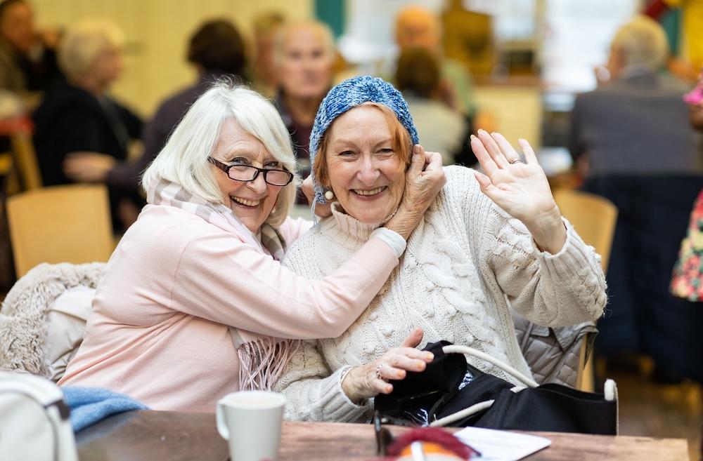 Women smiling at a community group