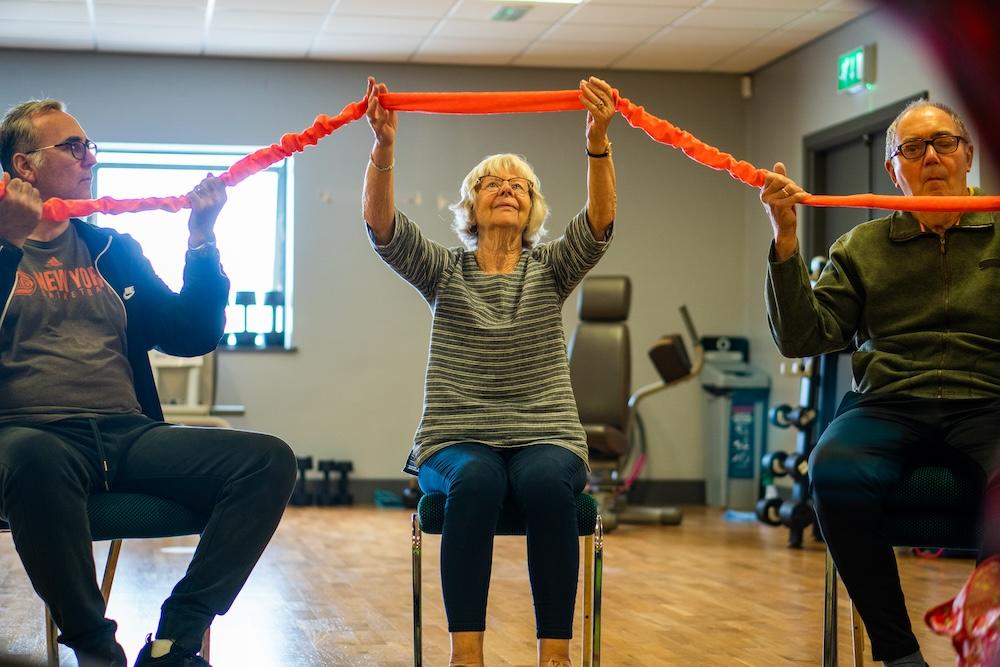 Woman holding up ribbon in activity class