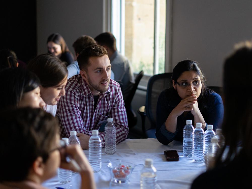 Early career researchers at workshop sitting around a table