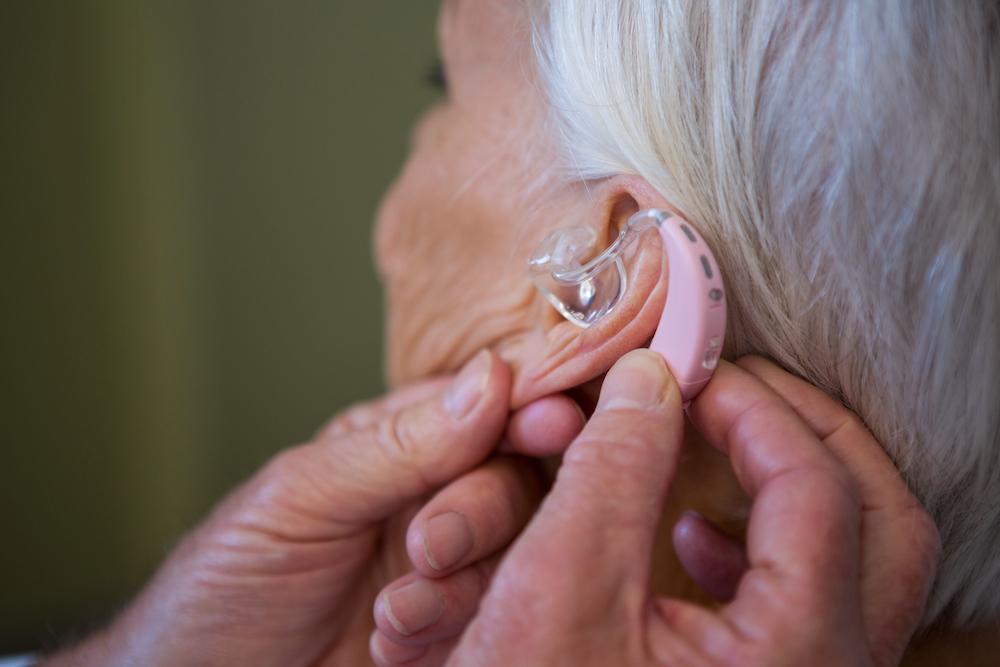 A woman having a hearing aid fitted